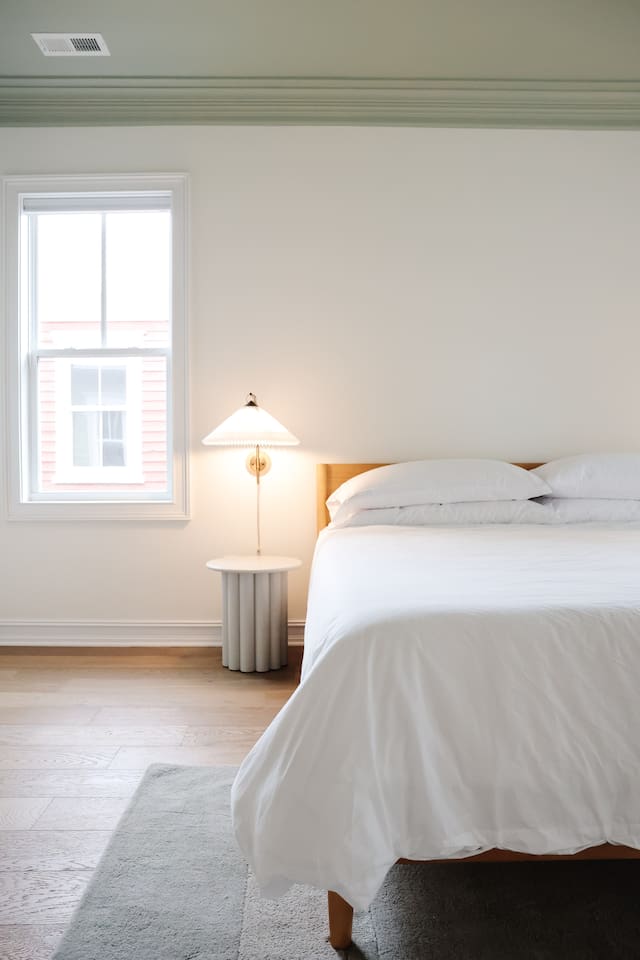 The spacious primary bedroom is a serene place to relax and recharge. The primary features a king sized bed, accents from CB2, walk-in closet, 50" Smart TV, and a full bath with a soaking tub and standup shower. 