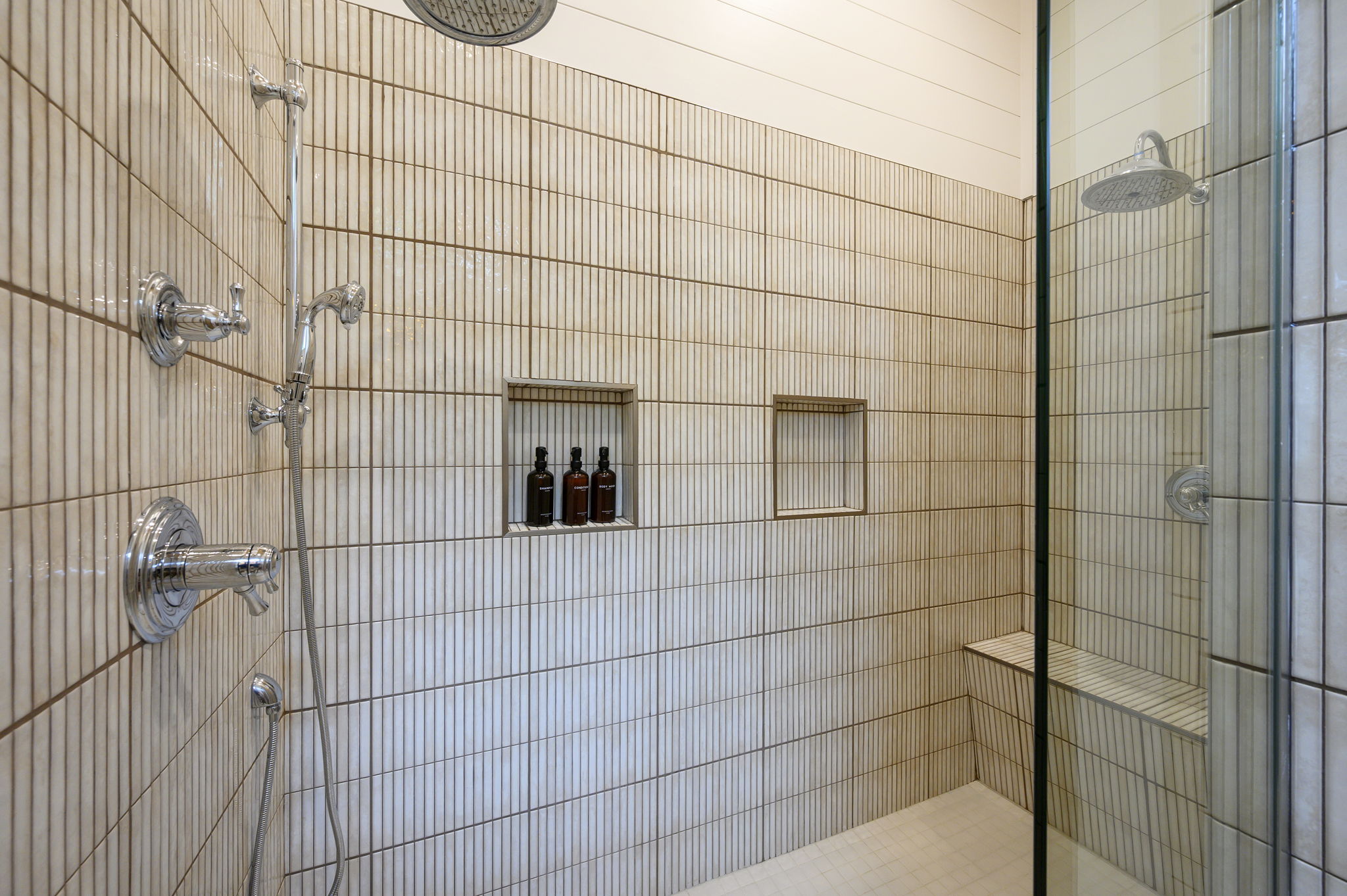 The primary ensuite bathroom offers a warm, spa-like experience with high-end finishes, luxurious touches, and a serene atmosphere designed for comfort and relaxation.
