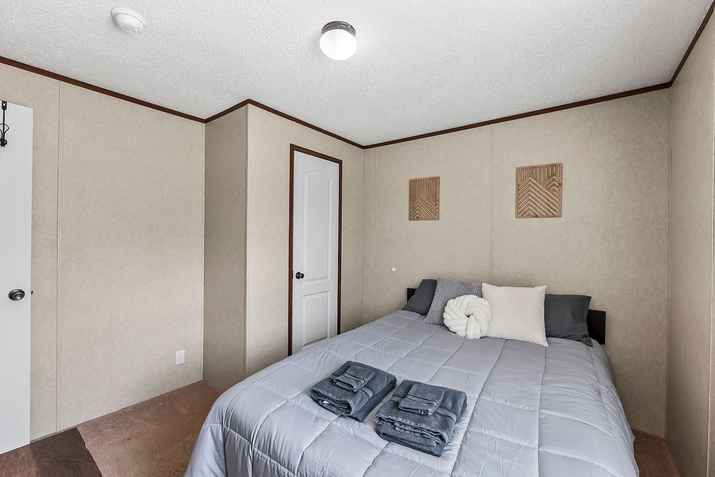 Bright and simple bedroom setup with neutral tones, cozy textures, and a peaceful ambiance for restful nights.