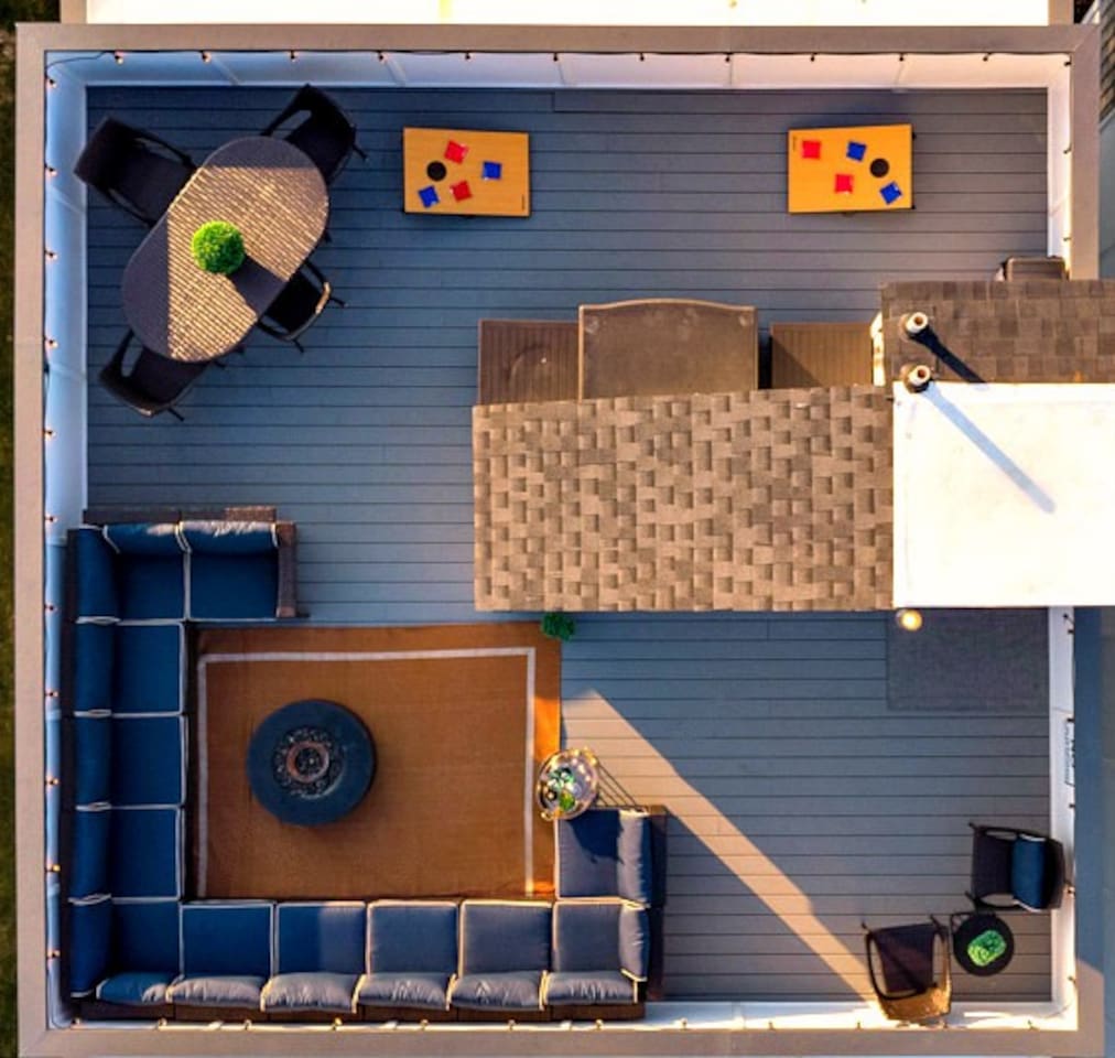 - Aerial view reveals a sprawling rooftop deck with multiple seating zones and a firepit - Spacious sectional lounge, dining set, and cozy nook offer comfort and flexibility - Ideal for hosting, relaxing, or enjoying city views under the stars