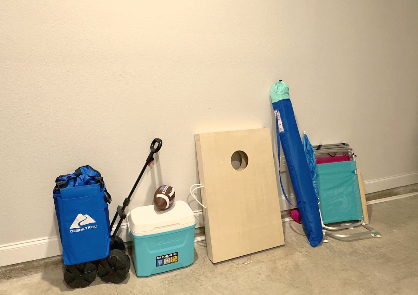 Grab the cornhole boards, football, cooler packed and ready. Beach chairs stacked, easy to load up and go. Everything set for a fun day outside, no planning required.
