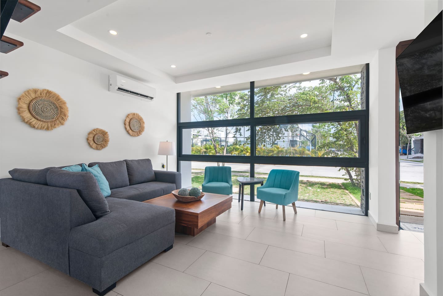 Living space with TV and comfortable couch overlooking the tennis court on the main floor.