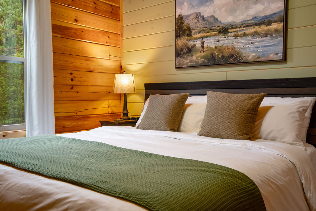 King bedroom with the details curated for comfort- from plush bedding to cozy cabin ambiance