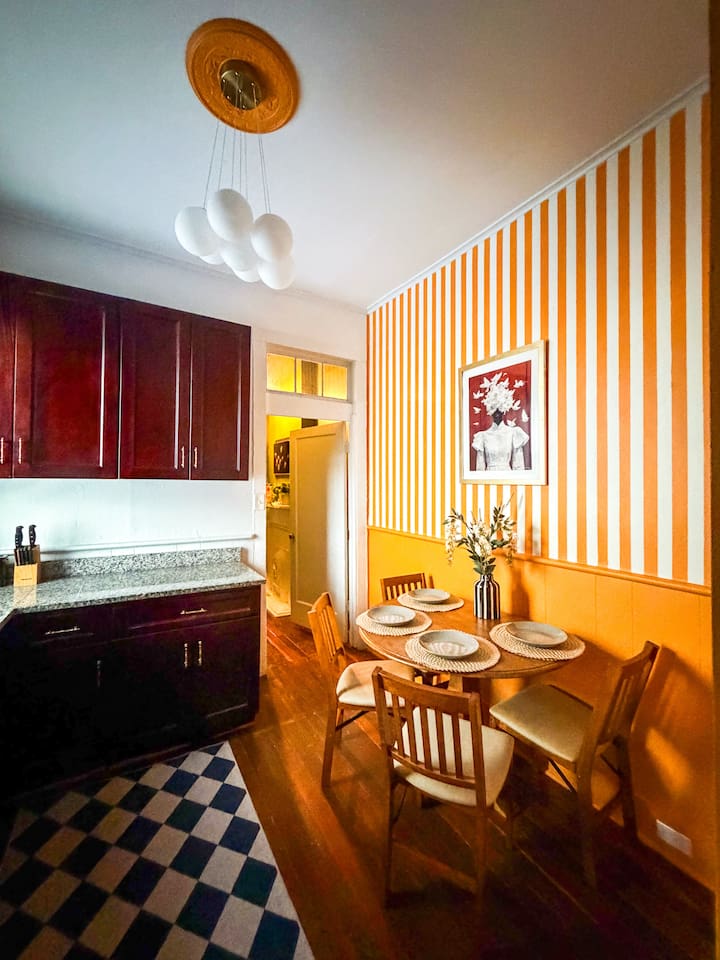 Bright kitchen and dining space with playful striped walls and seating for group meals. Fully  equipped for cooking, coffee, and brunch before exploring the French Quarter. And dining for 6 people! 