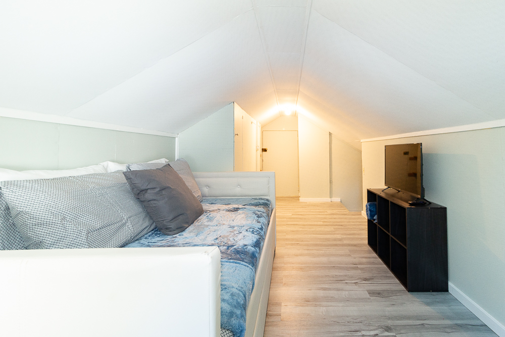 The loft creates a cozy hideaway, ideal for relaxing with a book or movie.