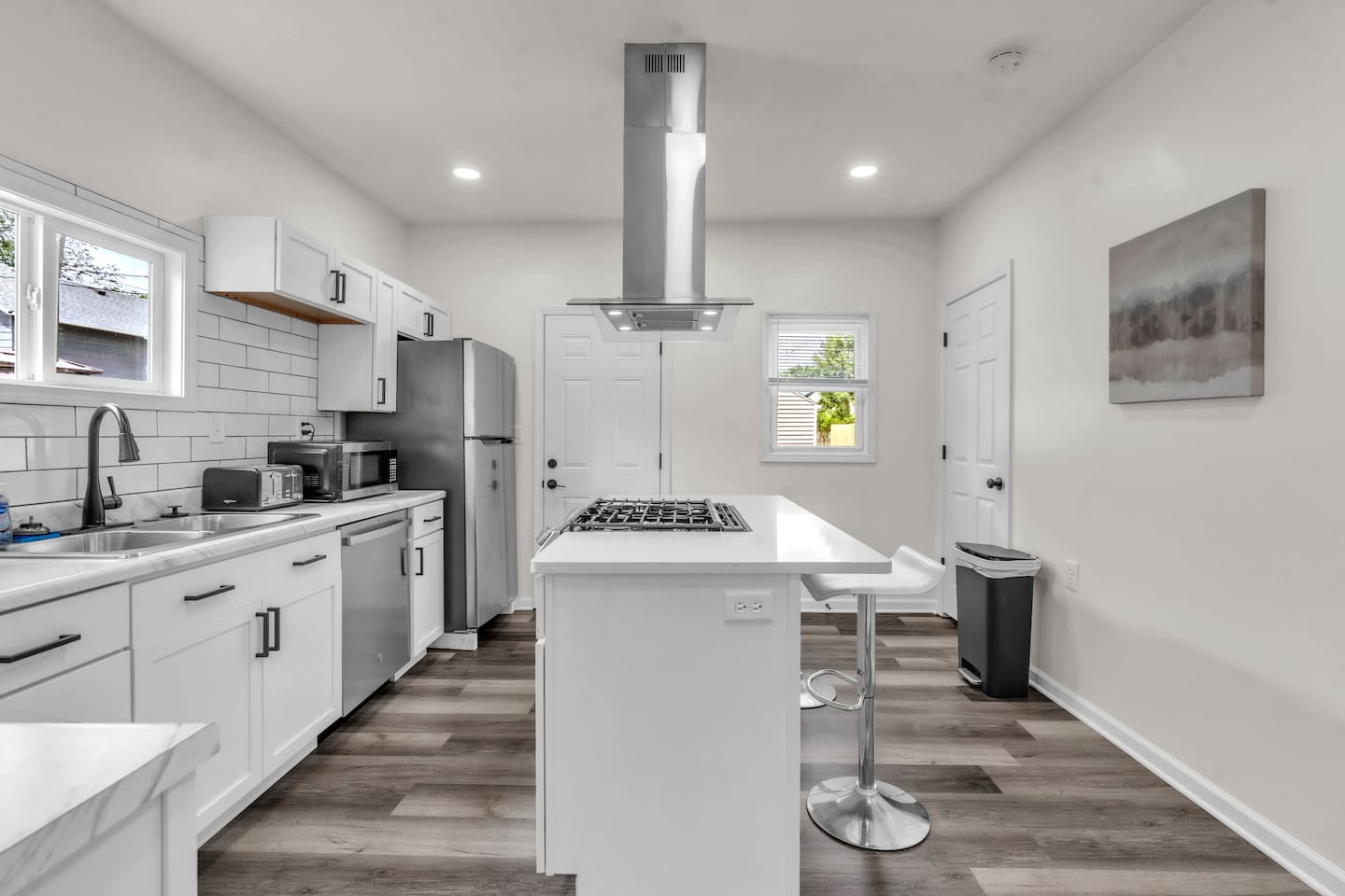 The kitchen boasts an elegant design with a center island featuring a burner, and a fridge, offering both style and practicality.
