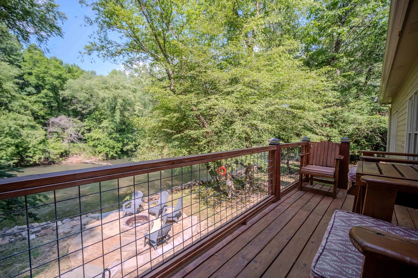 This peaceful back deck offers the perfect spot to sip your favorite drink, listen to the river below, and soak in the serene surroundings. Comfortable seating and natural privacy make it a guest favorite for unwinding.