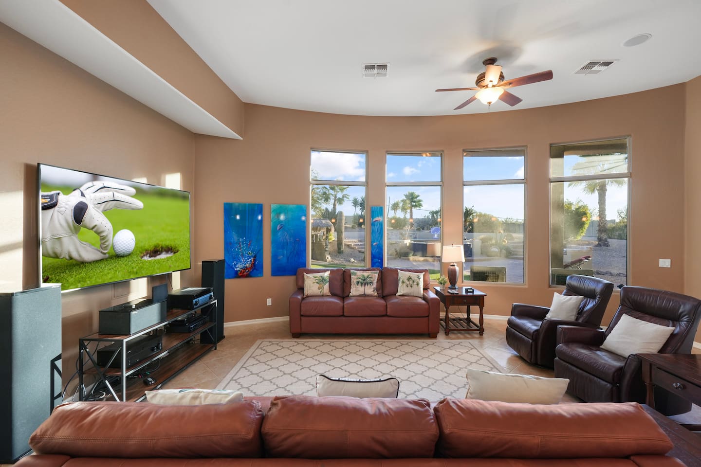 Comfortable living area with oversized windows and views of the private backyard oasis