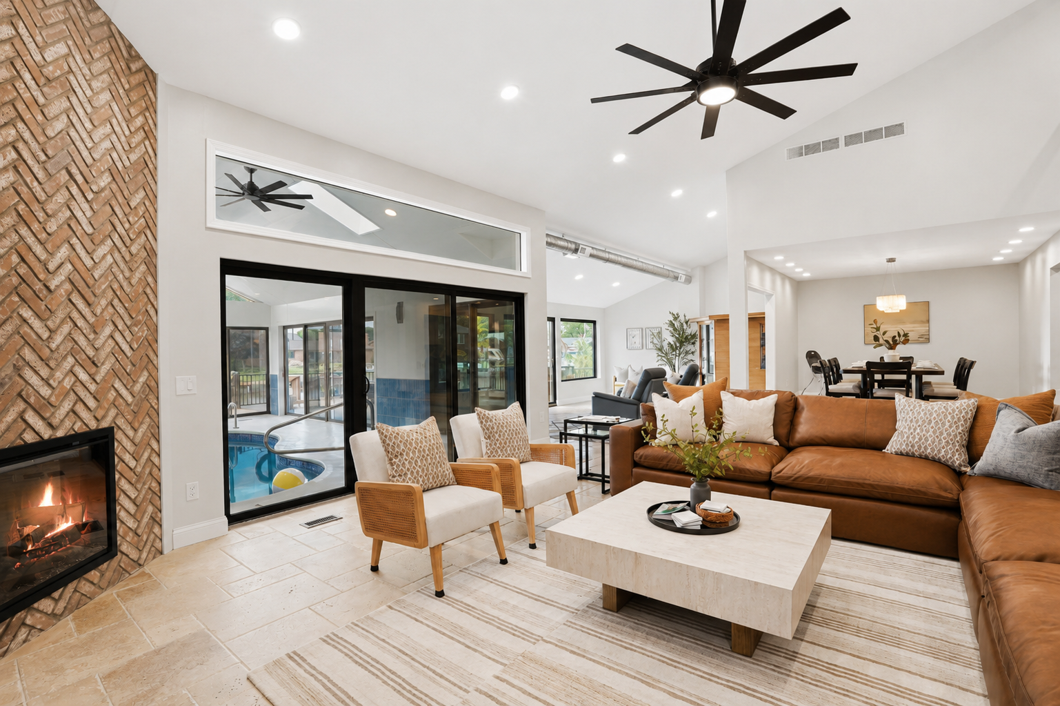 Gather with family and friends in this stunning open-concept living room with soaring ceilings, abundant natural light, spacious sectional seating, and a seamless modern coastal design connecting living, dining, and loft areas.