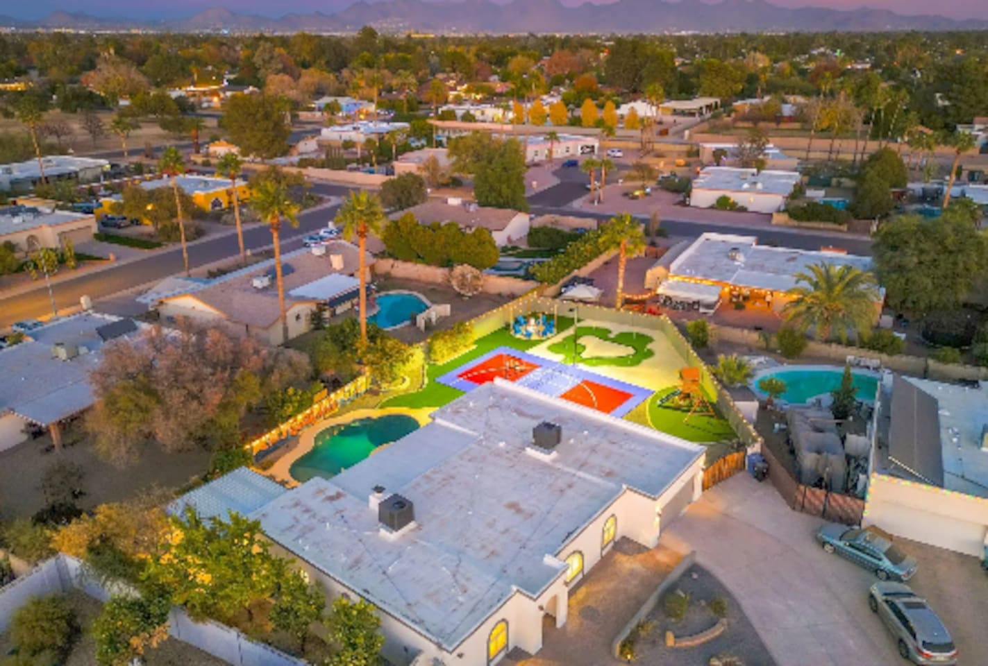 A backyard built for a crowd: pool, sport court, and putting green, all on one oversized lot.