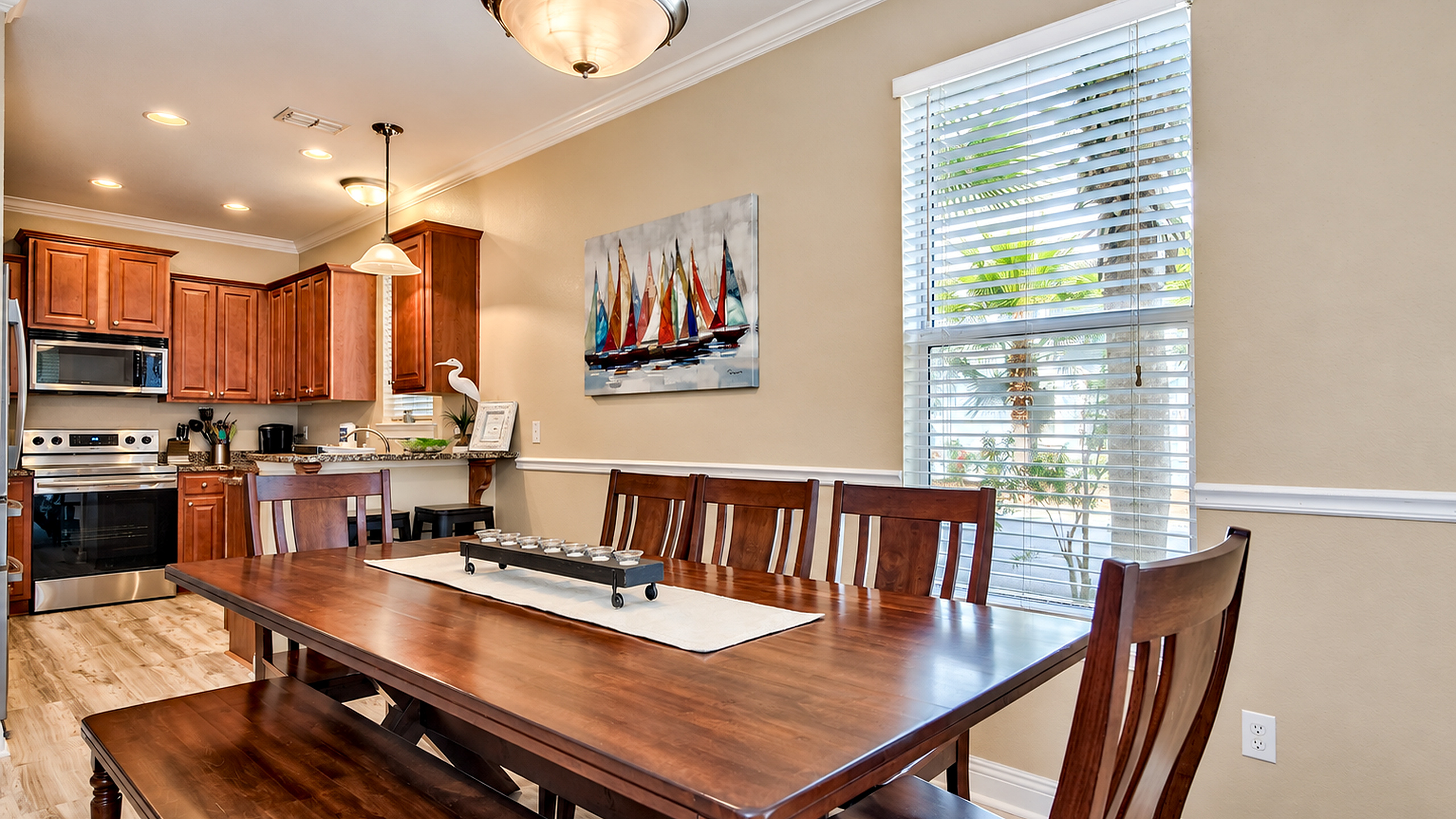 Spacious dining area featuring a large 8–9-seater coastal table, with a kitchen bar for two.