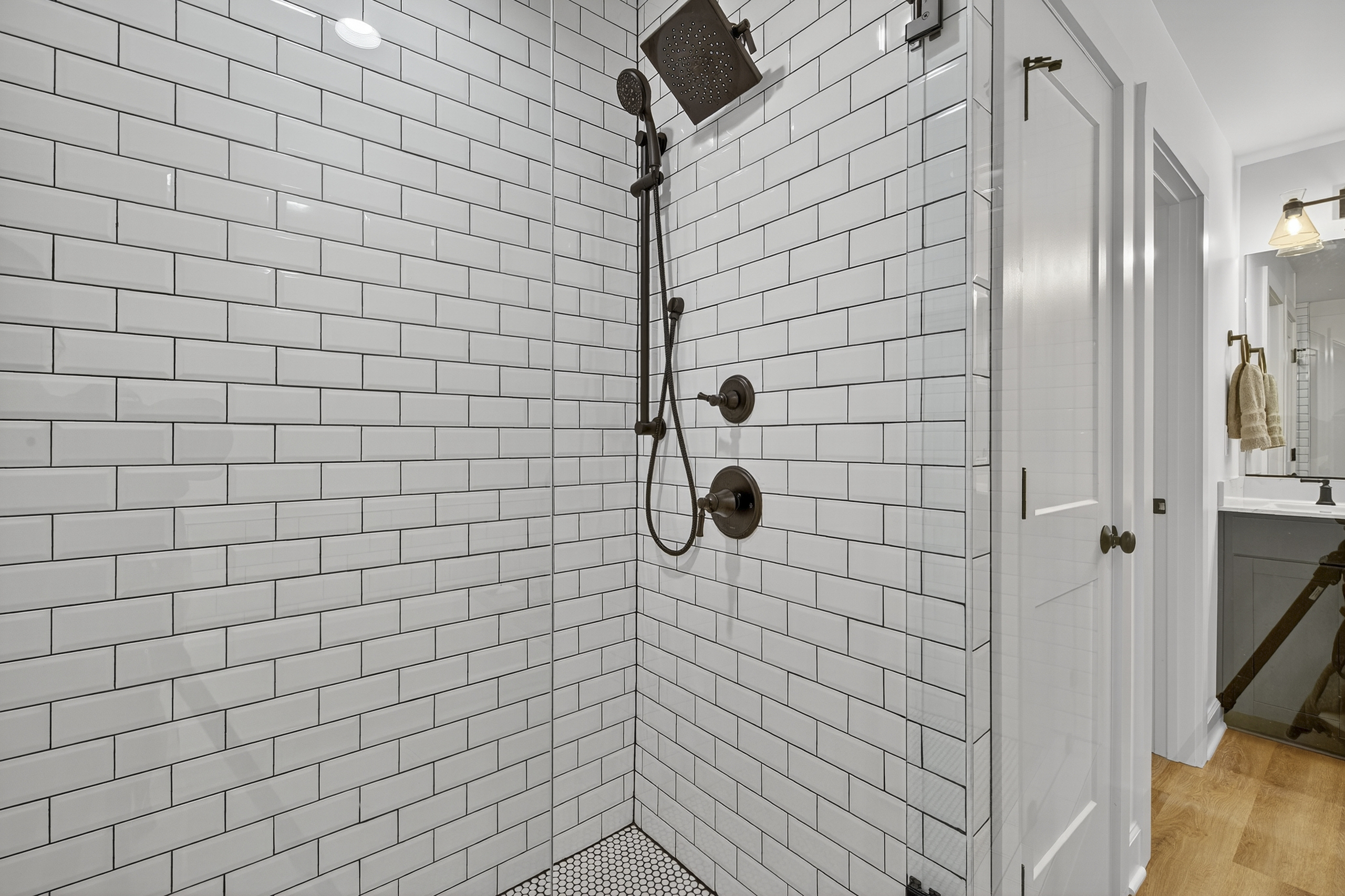 Step into a spacious walk-in shower framed in timeless subway tile, complete with sleek black fixtures for a modern touch.