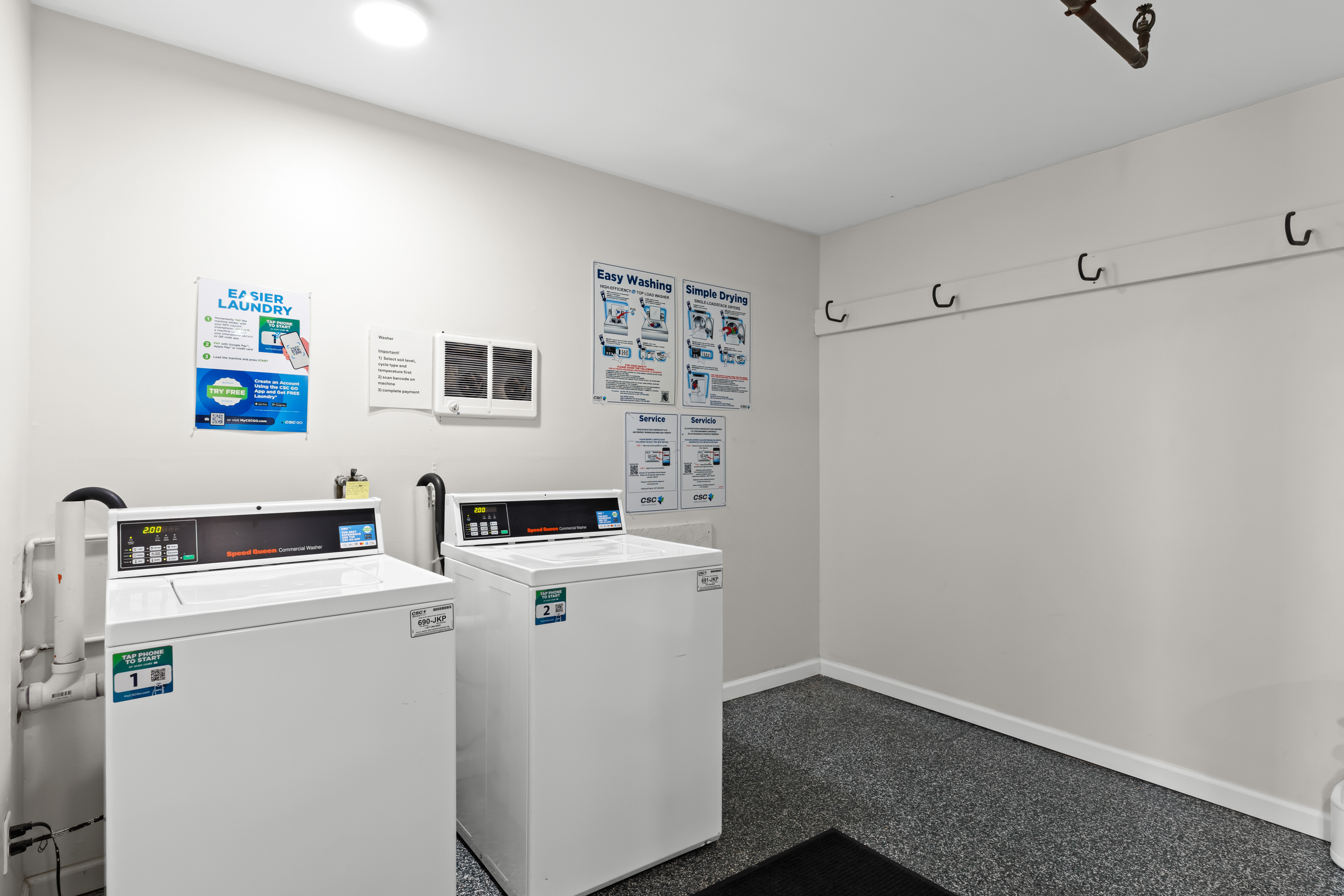 Multiple machines available in the shared laundry room—accepts quarters and digital payment.