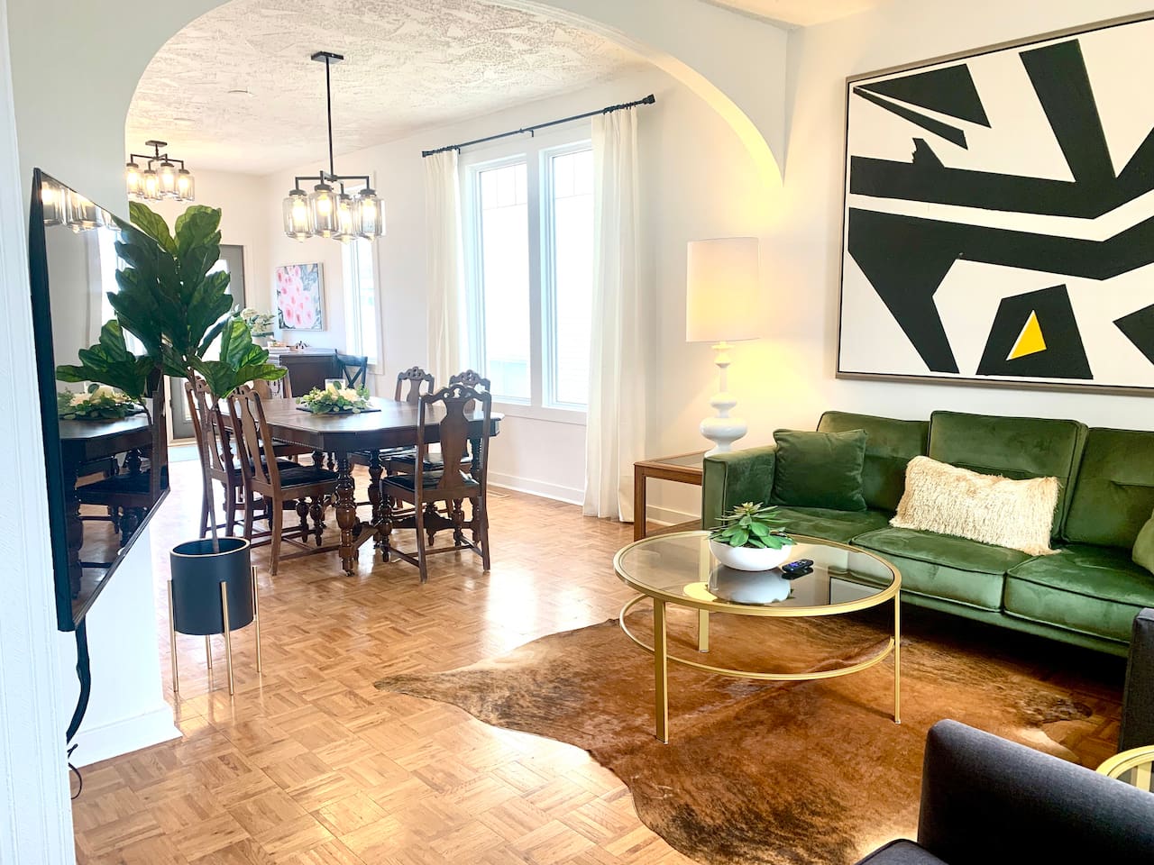 Open concept main-floor living-dining room area. High textured ceilings with tall windows allowing in natural light. 