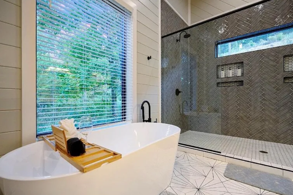 Spa-like bathroom with soaking tub and large window views.