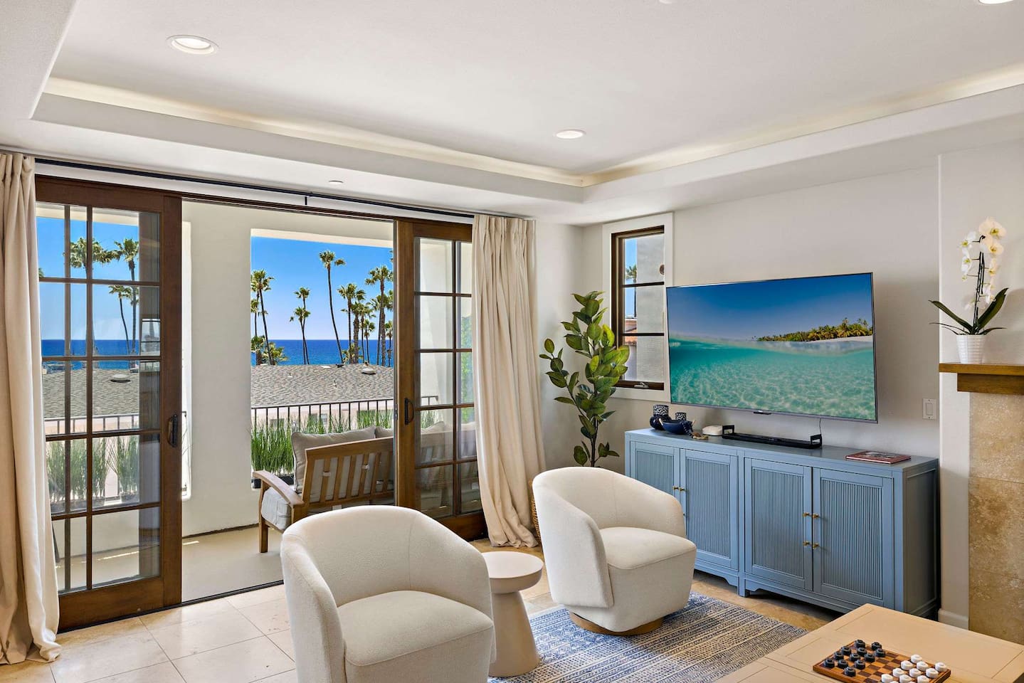 The living room has lots of comfortable seating, views and natural light pouring in from the balcony.