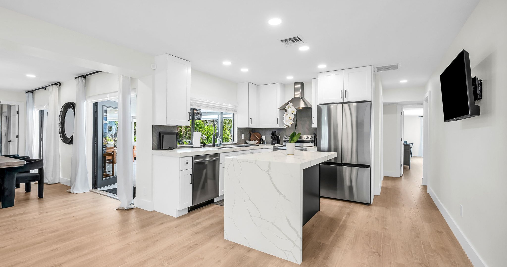 Bright and airy, this modern kitchen combines luxury finishes with everyday comfort. Enjoy the designer backsplash, expansive counter space, and seamless flow to the dining and living areas.