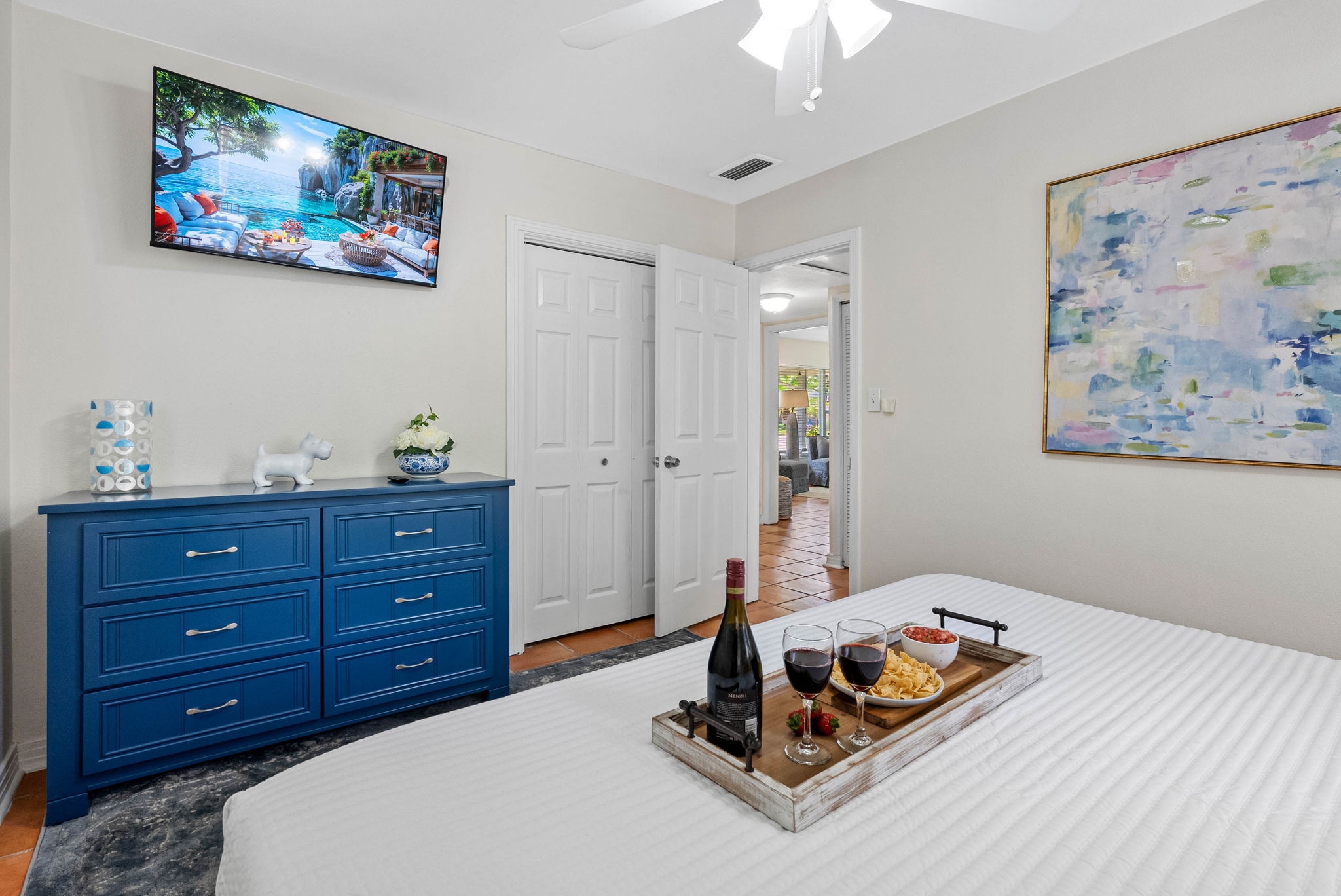 The navy dresser adds a pop of color and storage, while the wall-mounted smart TV lets you enjoy your favorite shows from bed.