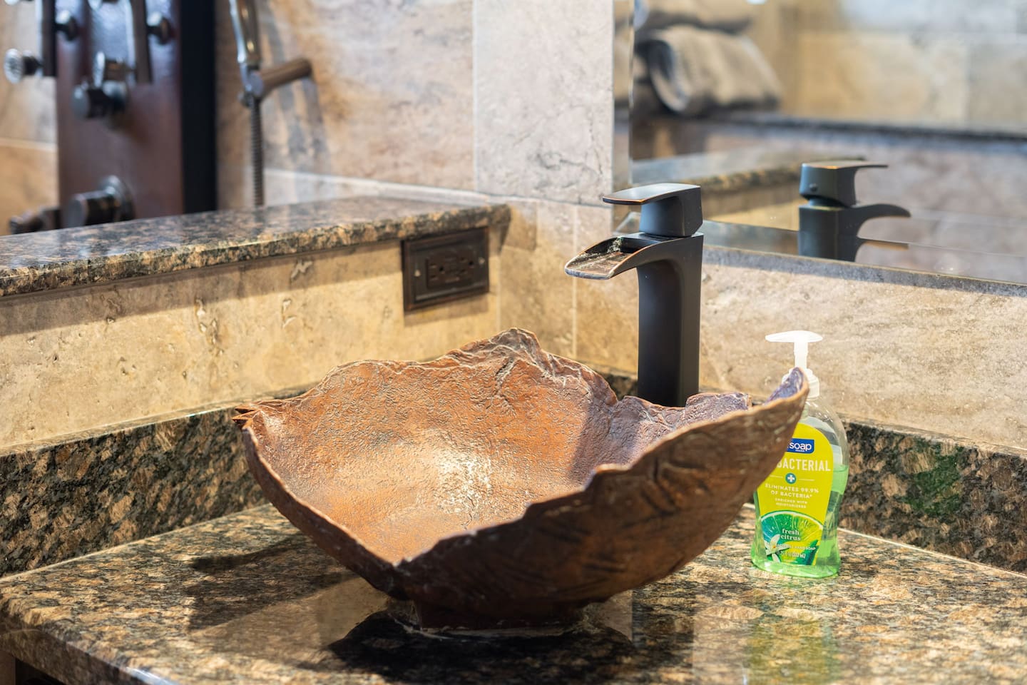 The hand-hammered copper vessel sink is a work of art in itself — paired with a sleek matte black faucet and granite counter, it's the kind of detail that makes guests stop and look twice.