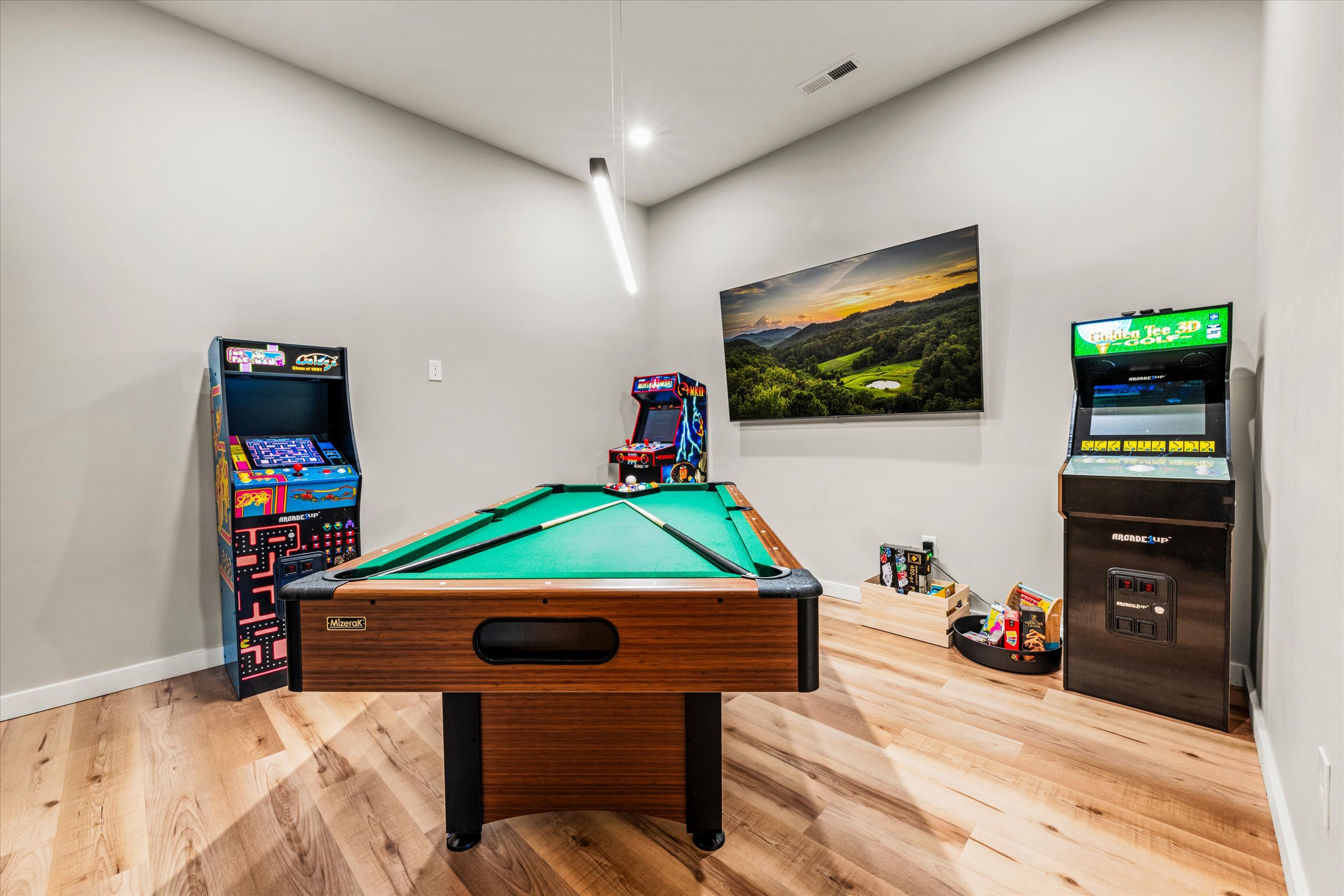 The game room is located on the lower level near the pool and includes multiple arcade games, Large TV, Board Games, billiards table, row game, baby books and toys.
