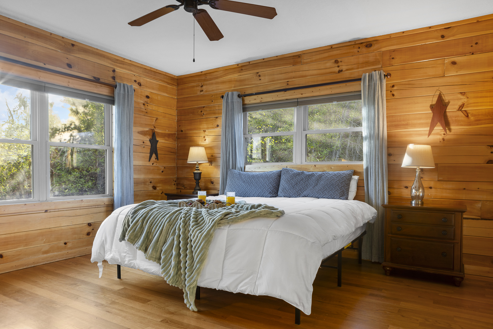 Bedroom Retreat: Bright, wood-paneled haven with plush bedding and scenic views to inspire relaxation!


