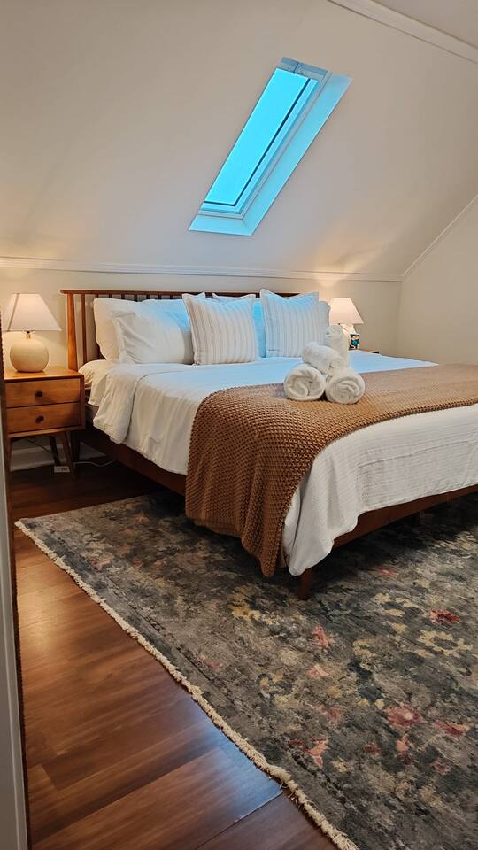 Cozy bedroom with warm lighting and a comfortable King-size bed.