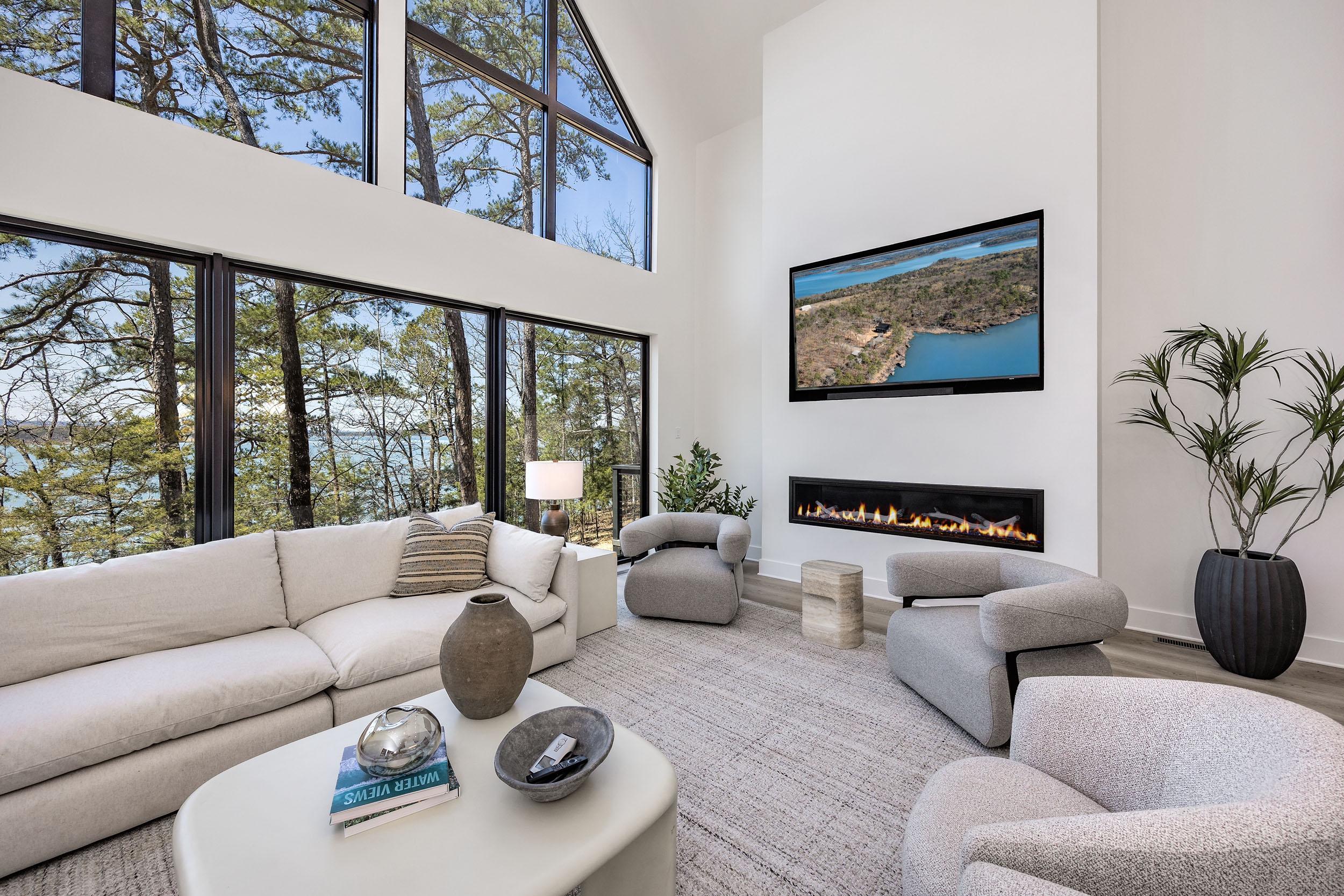 Vaulted ceilings, a wall of windows, and a fireplace make this the heart of the home—perfect for gathering, relaxing, and taking in lake views.