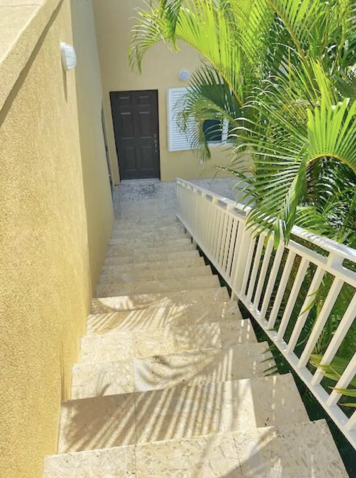 Easy-access entry with wide steps and tropical landscaping—private and peaceful fifth bedroom
