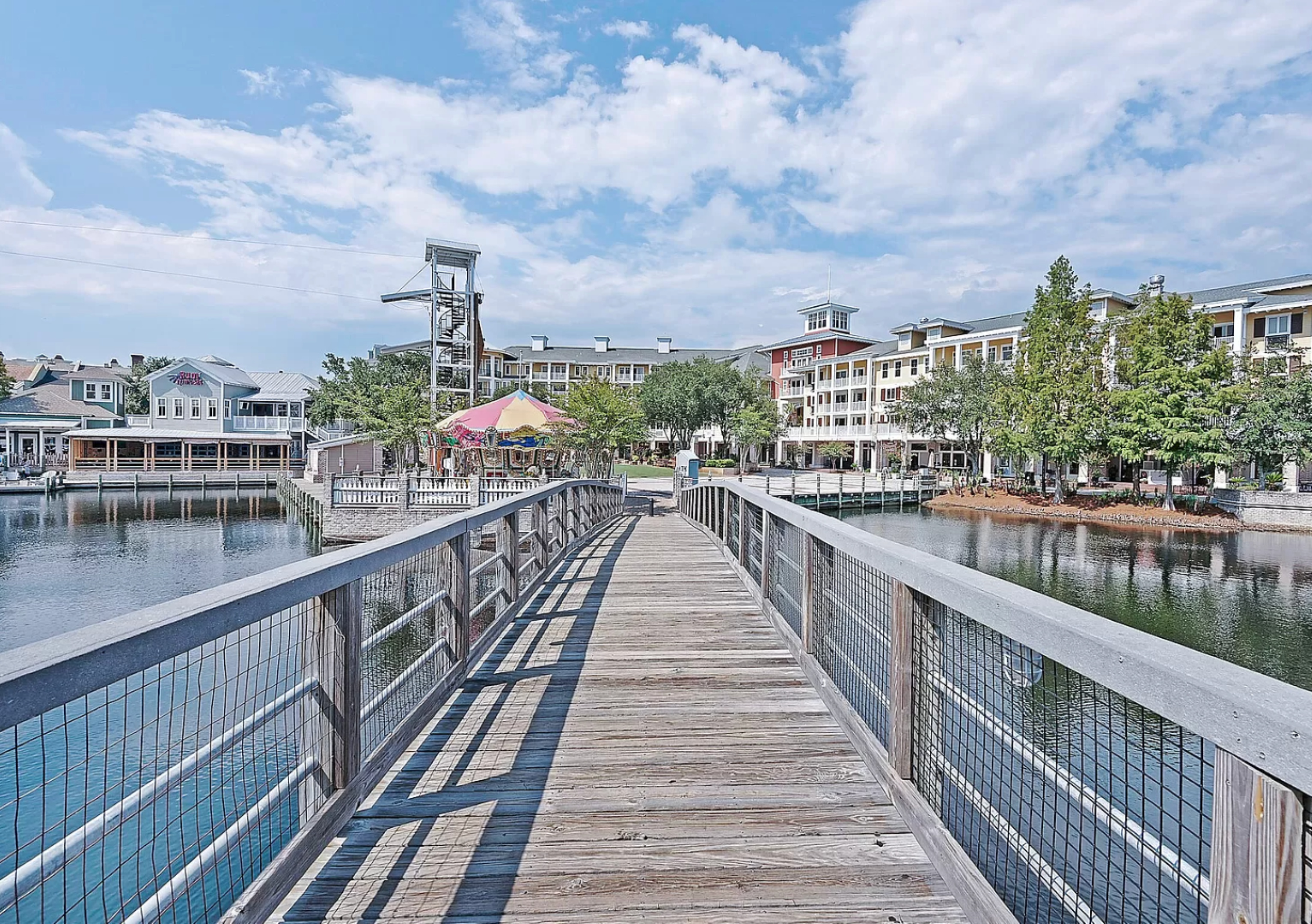 A beautiful walkway connects different areas of the resort, reflecting in the calm waters and creating a charming coastal atmosphere.