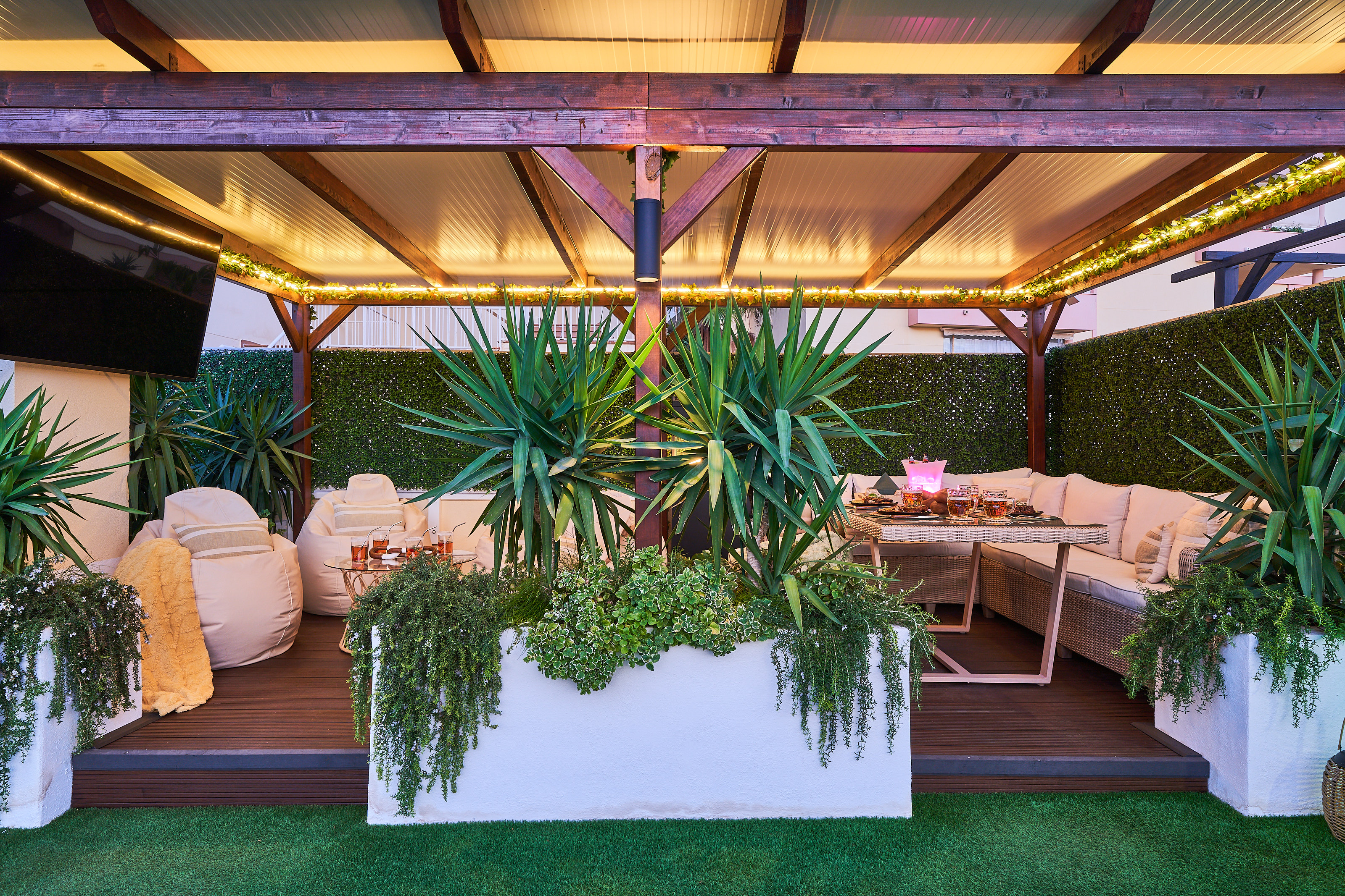 Relax beneath the covered pergola with cozy seating, fireplace, and dining area. Perfect for long evenings, romantic dinners, or movie nights on the outdoor TV under soft ambient lights.