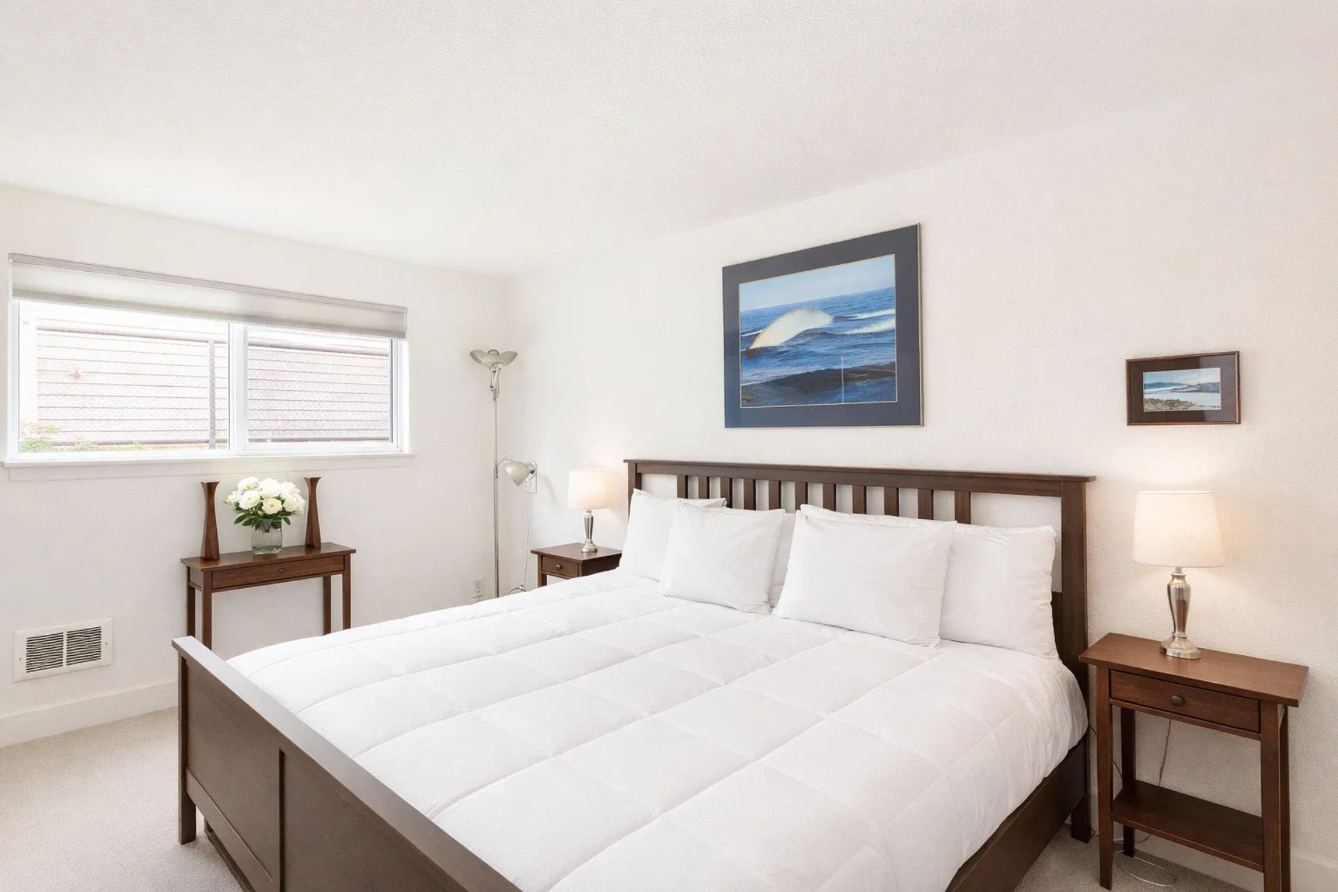 Main Bedroom: Bright and inviting retreat with king bed, modern decor, and serene ocean-inspired art.