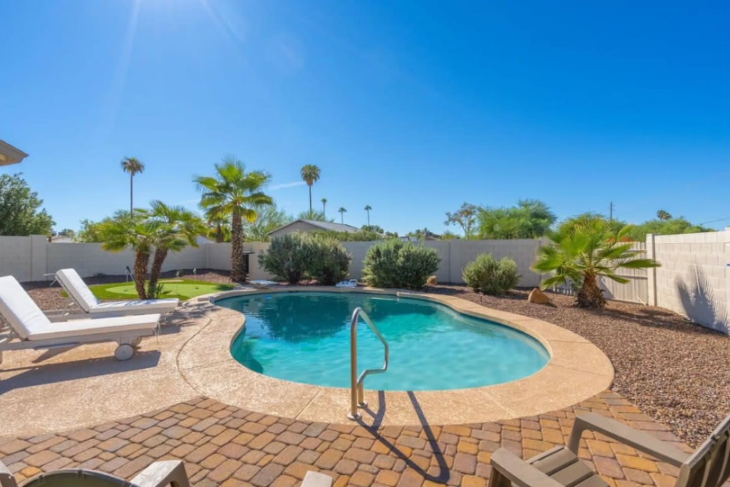 Resort-style pool with spacious deck, mature palms, and private fenced yard perfect for entertaining.