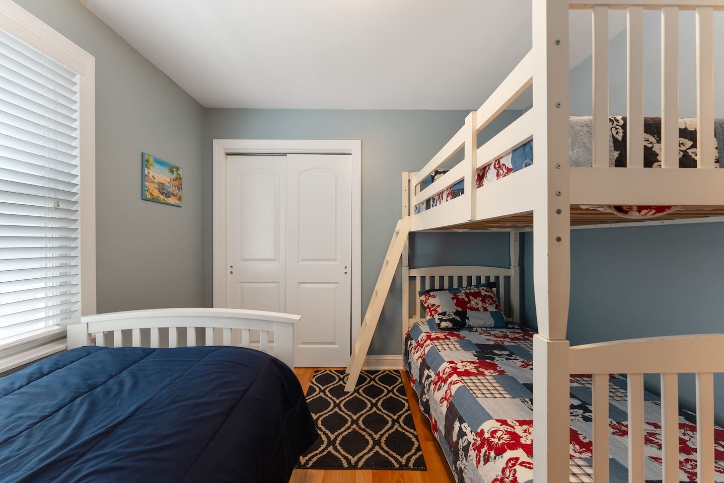 Bedroom features bunk beds and a single bed with a large closet for storage. 