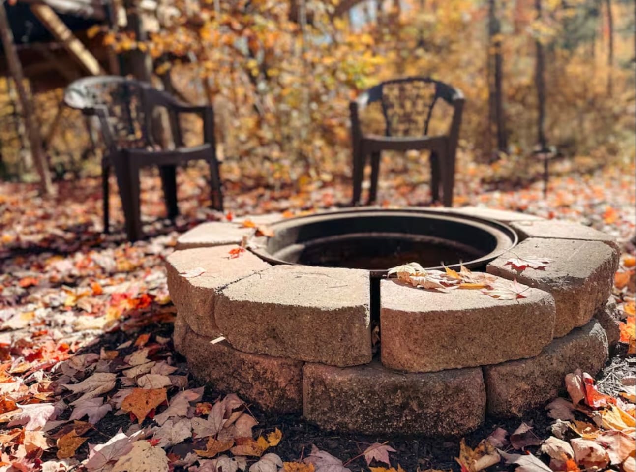 Cozy fire pit, with plastic chairs, perfect for relaxing evenings under the stars. Ample seating for everyone.