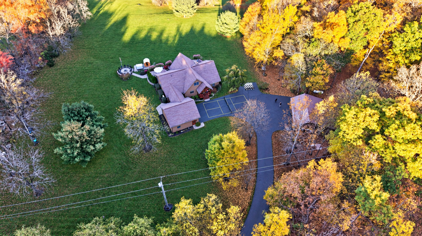 Aerial view of property surrounded by autumn trees