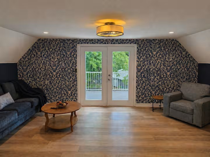 Comfortable second-floor loft with lounge seating, natural light and easy access to the upper deck with lake views.