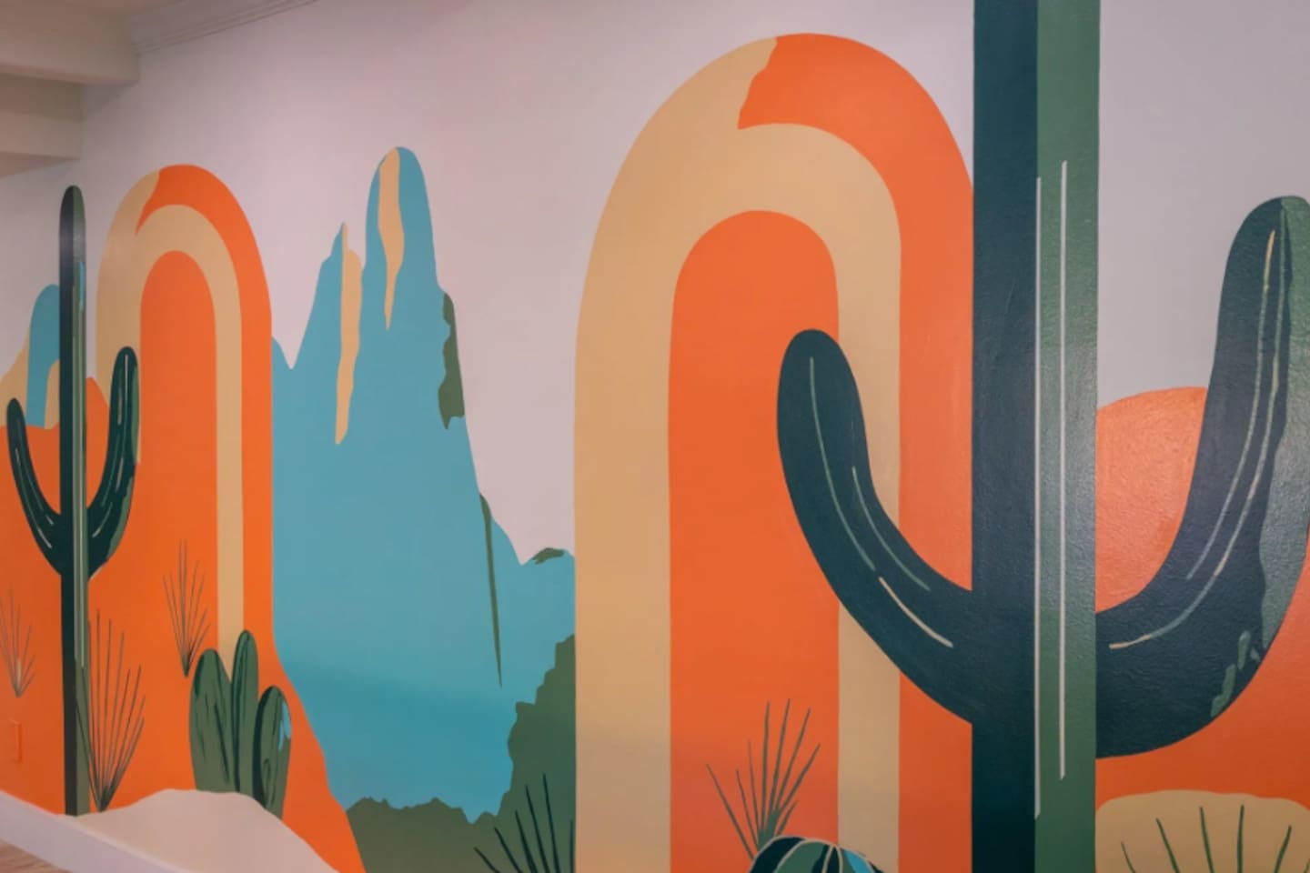 A bold, hand-painted desert mural adds color and personality to the space, a fun backdrop for photos.
