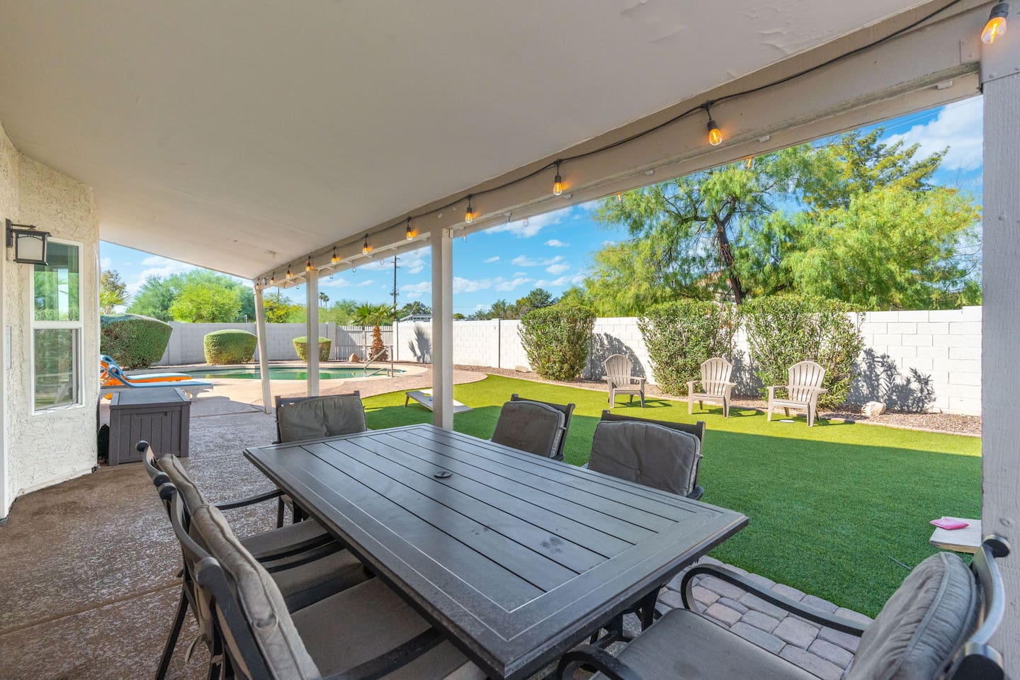 String lights overhead, pool glimmering beyond — outdoor dining at its finest.