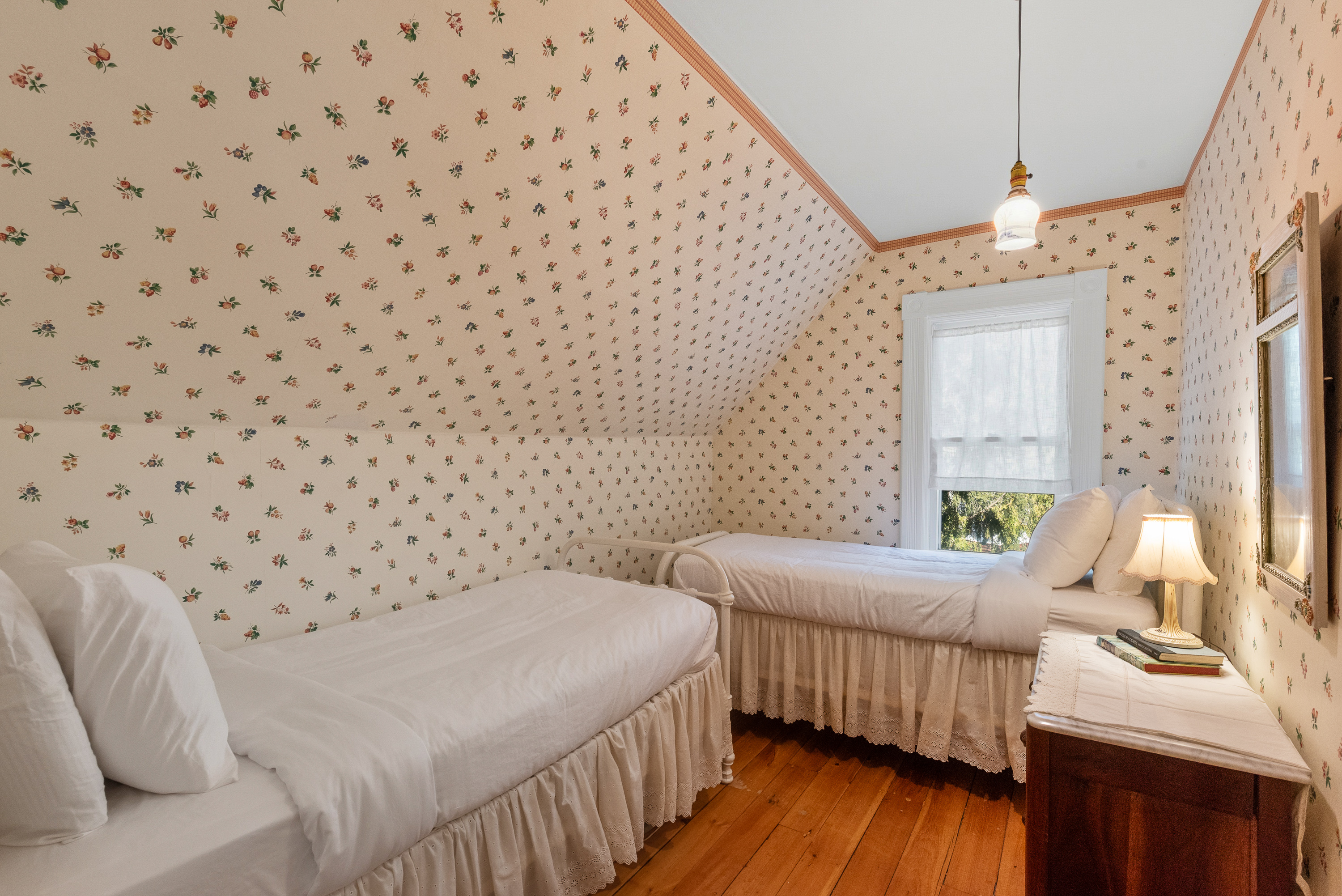 Twin bedroom w/ simple decor & warm, inviting tones