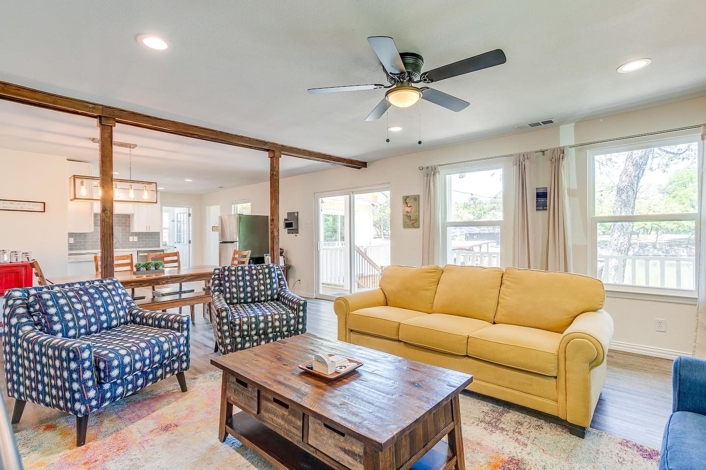 Spacious living area with abundant natural light, comfortable seating, and seamless indoor-outdoor flow to the lakefront deck.