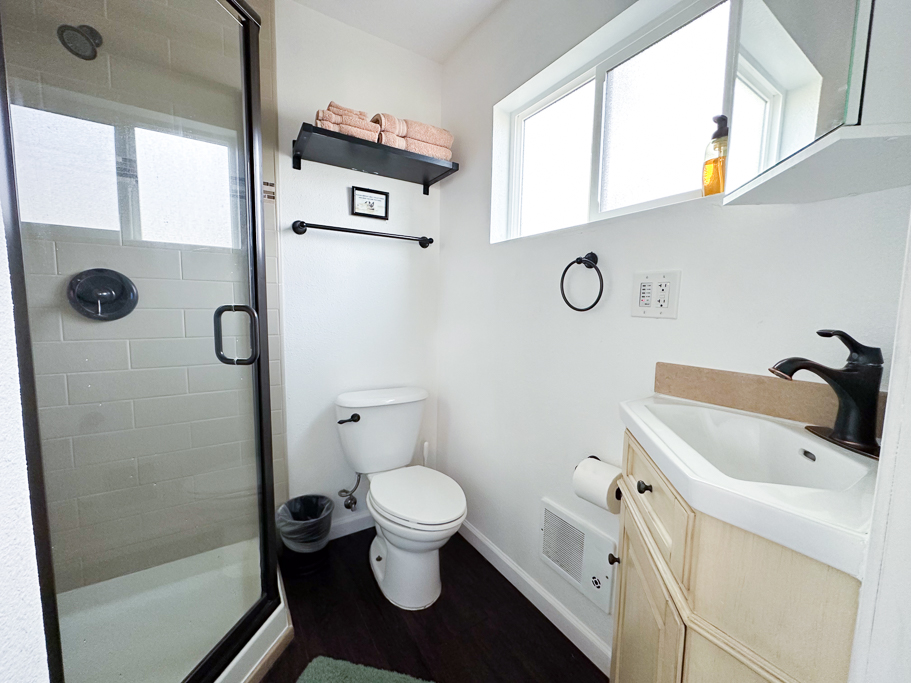 Crisp white bathroom w/ walk-in shower & bright finishes