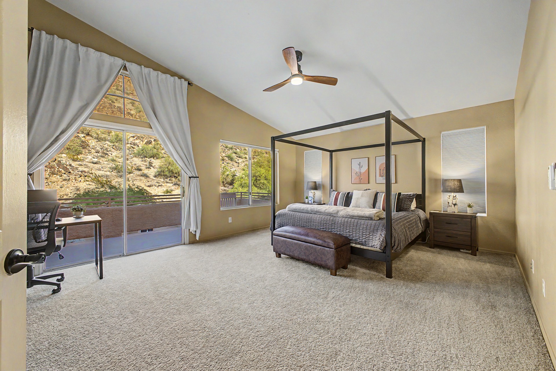 Primary suite with king bed, 55” smart tv, blackout blinds, ceiling fan, remote workstation, walk in closet, ensuite bathroom and private deck