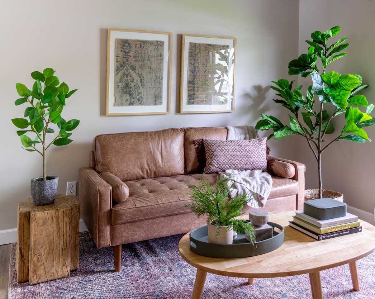 Rich leather seating paired with greenery brings a grounded, organic feel to the room.