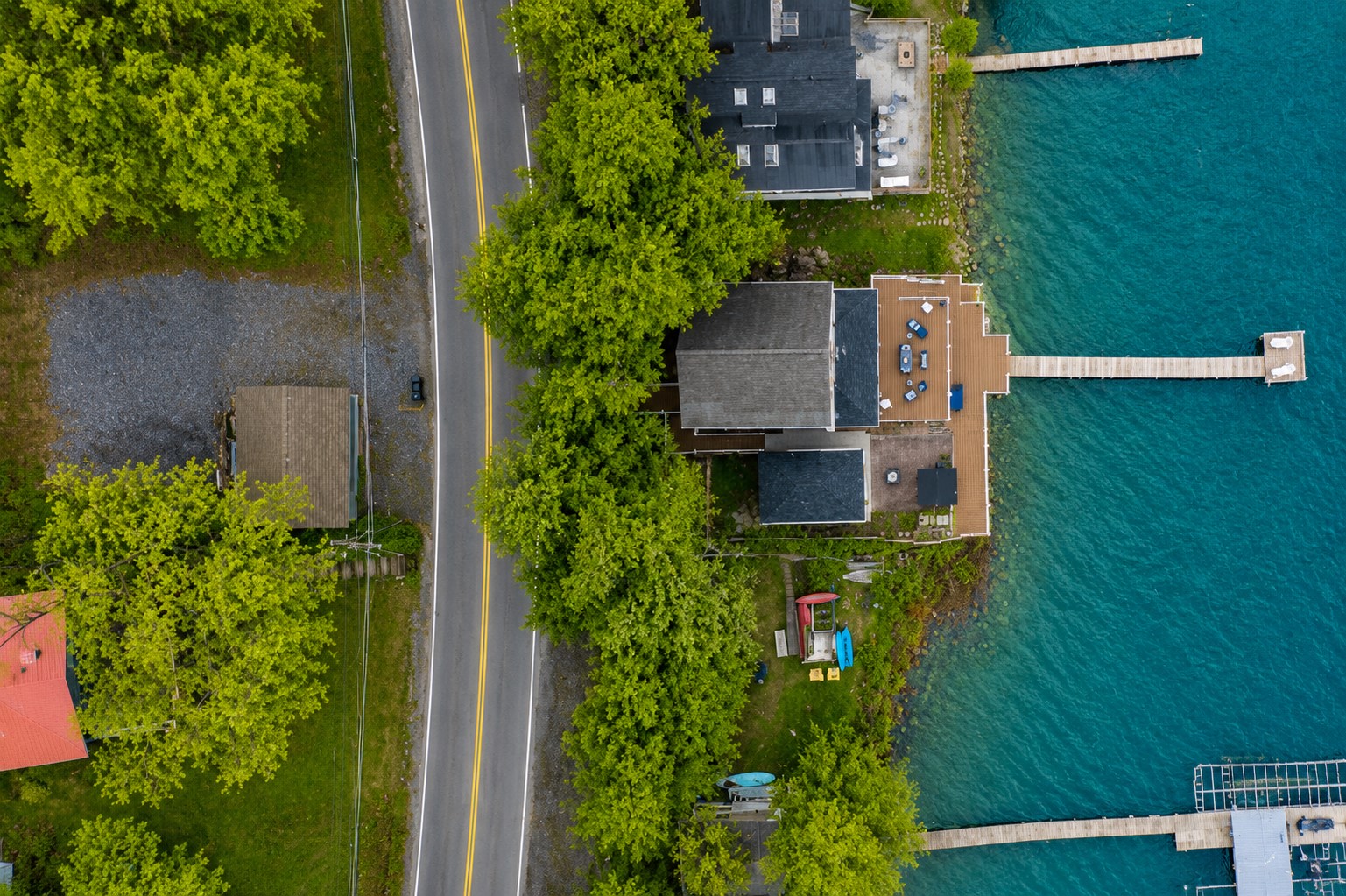 Aerial shot showcasing expansive lakefront entertaining space, hot tub, and private dock for the ultimate getaway 🎯🌊🍹