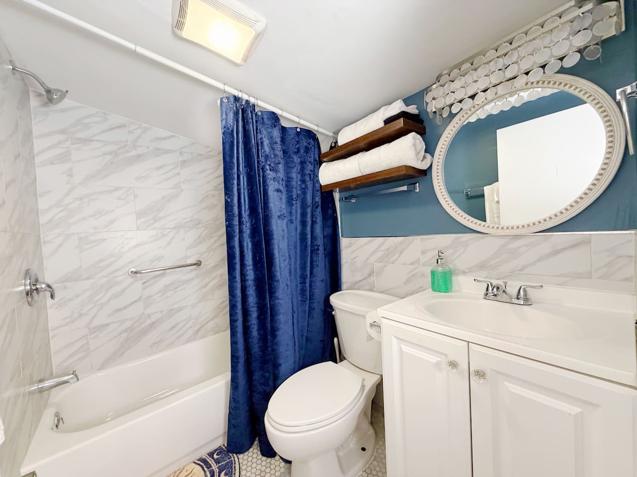 This en suite bathroom, accessible from the primary queen bedroom, is clean and modern with marble tile, plush towels, and a full bathtub. Perfect for relaxing after a long day exploring the French Quarter and Marigny. 