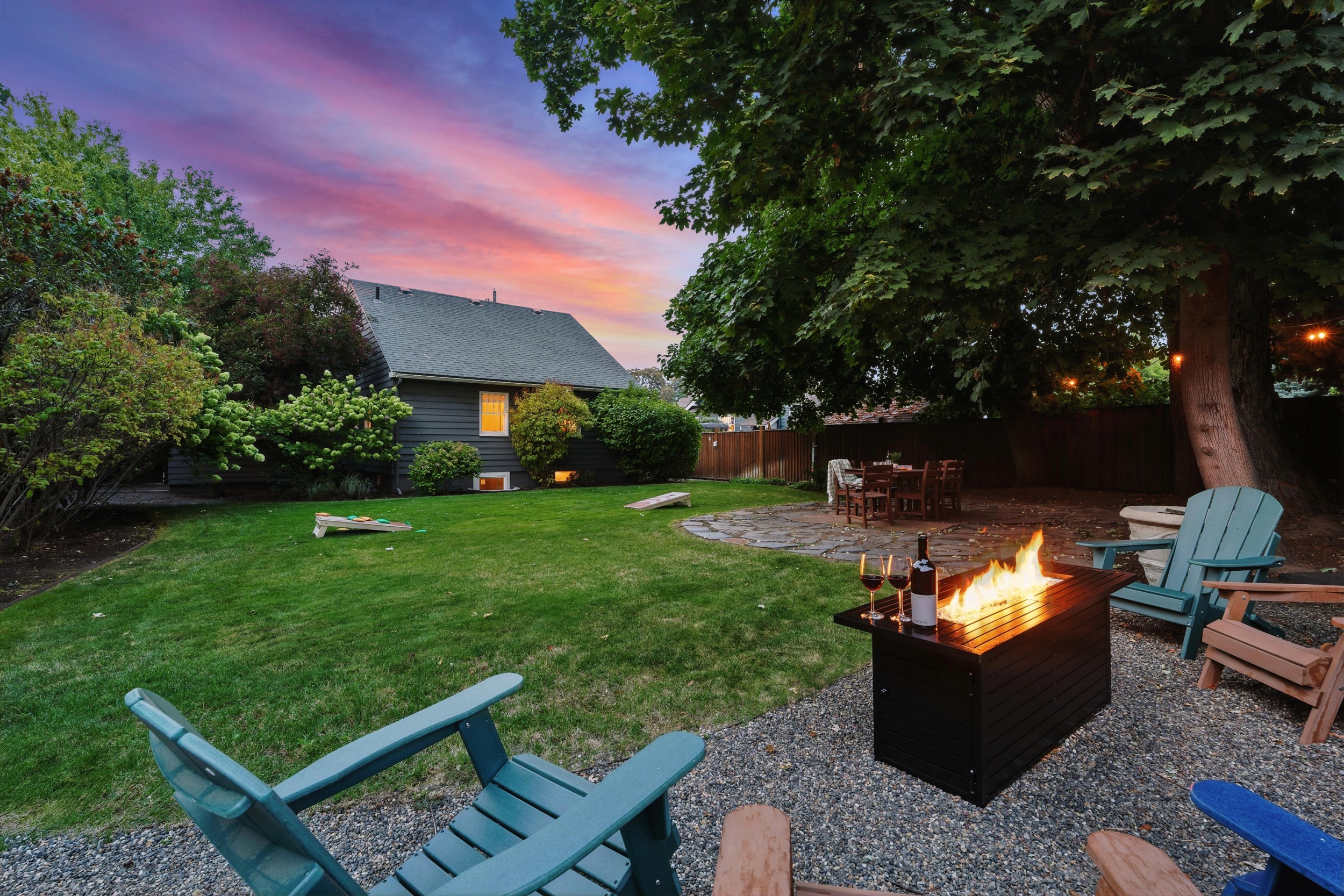 Large backyard with a park-like setting, outdoor dining for 6, corn hole, and 6 lounge chairs gathered around the propane fire table (propane provided)