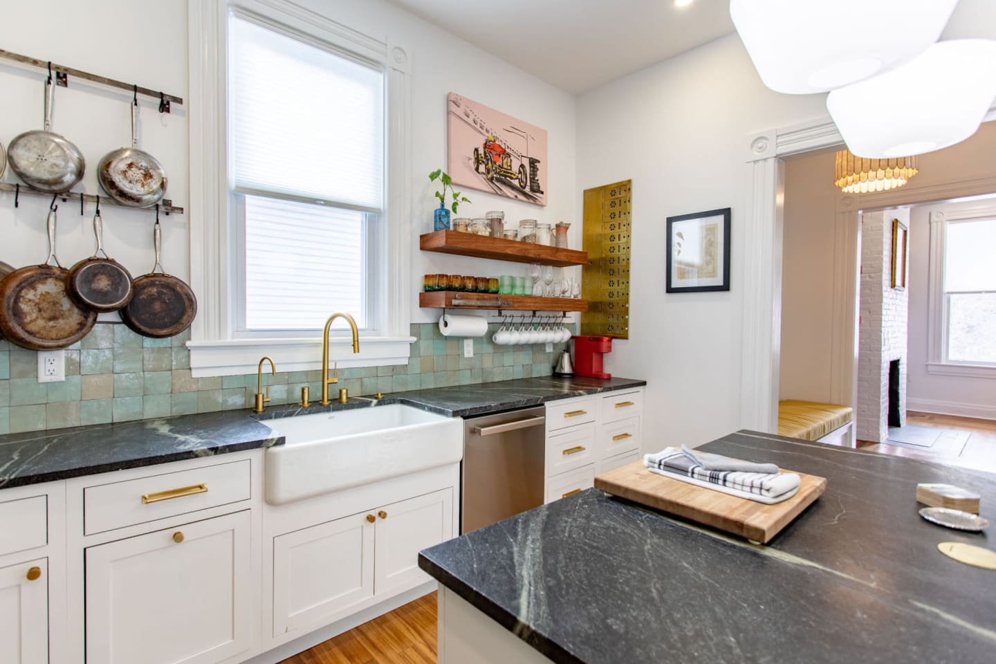 A well-equipped kitchen showcasing a variety of kitchen wares, including neatly arranged pots, pans, and utensils, with a clean, functional sink area that adds to the overall practicality and charm of the space.