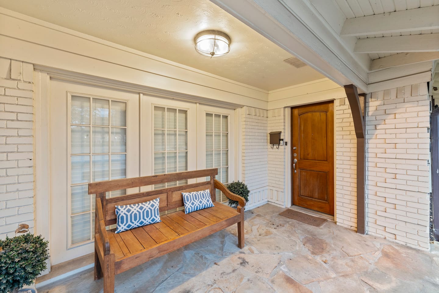 Charming private entry with cozy bench seating—perfect for morning coffee or welcoming guests in style.