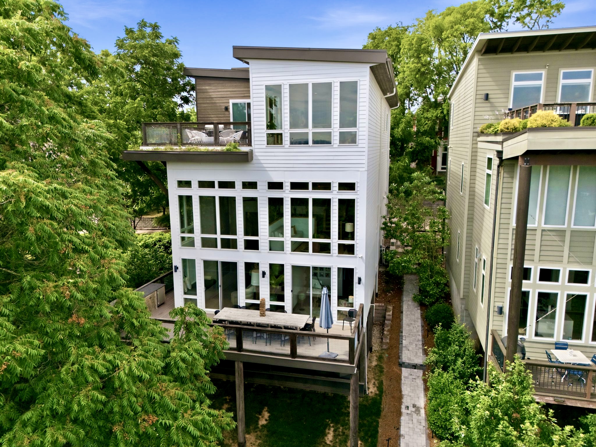 Treetop exterior shot showcasing the home's multi-level design surrounded by lush greenery.
