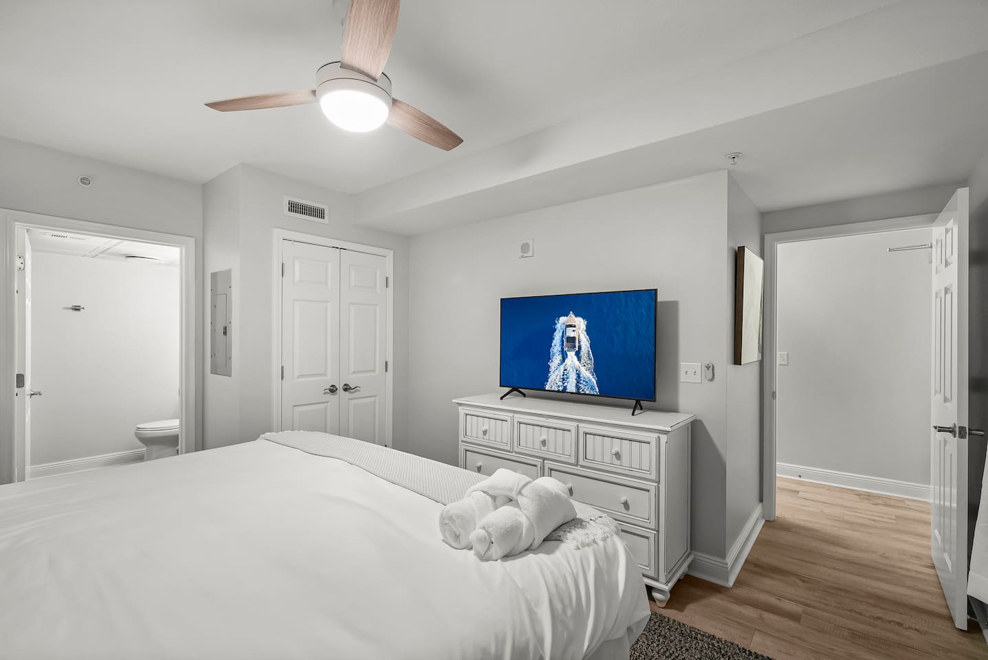 Relax and recharge in the cozy primary bedroom featuring a comfy king bed, smart TV, and direct access to a private en-suite bathroom—your peaceful beach retreat awaits!